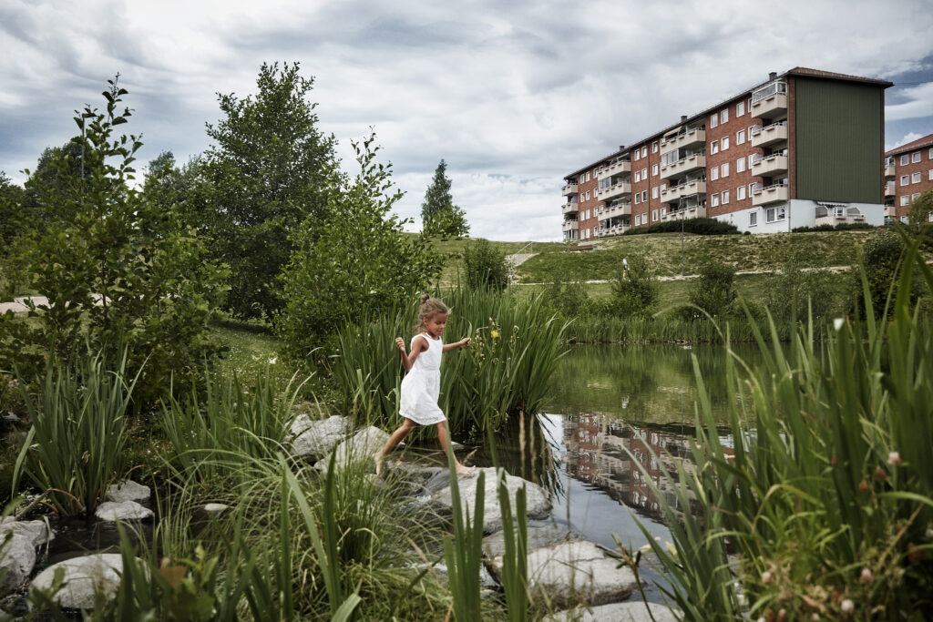 Barn som leker i en park med en blokk i bakgrunnen