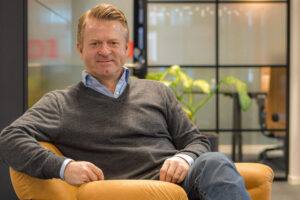 Halldor sitter i en stol med armen på armleende
