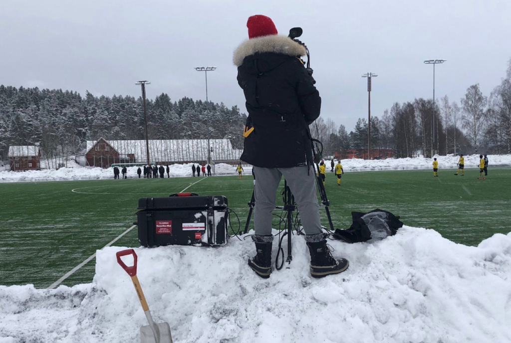 Bilde av mann som filmer fotballkamp
