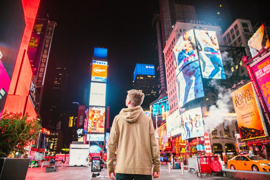 Gutt som speider ut over alle inntrykkene på Times Square i NYC